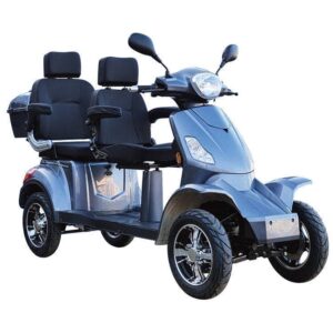 De For Motion Fast DUO is een strakke, zilverkleurige, vierwielige scootmobiel voor twee personen, met armleuningen, stuur, spiegels en opbergruimte achterin.