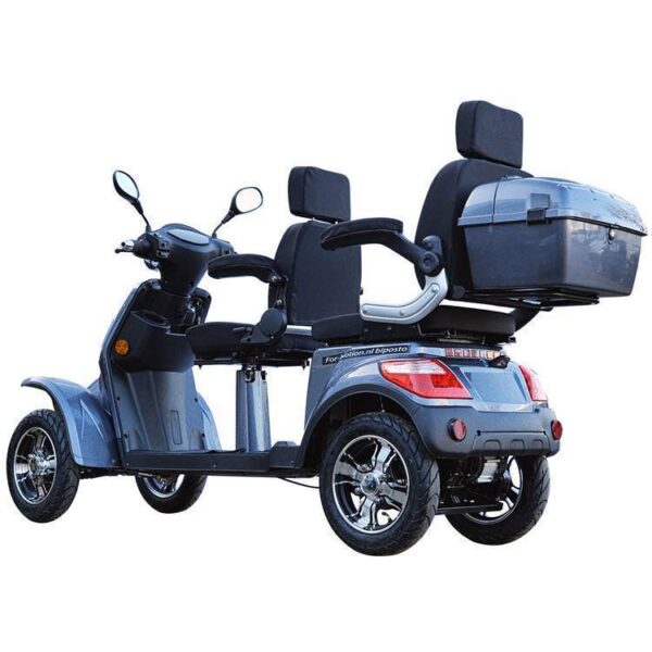 De For Motion Fast DUO scootmobiel is een grijze, driewielige scootmobiel die is ontworpen voor twee personen. Hij beschikt over twee zwarte, beklede stoelen met rugleuningen en armleuningen, een opbergvak achter de achterbank en wielen met chromen accenten.