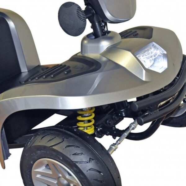 Close-up van de voorkant van de Kymco New Super 8 4-wiel mobiliteitsscooter, waarbij het wiel, de vering, het treeplankgedeelte, het grijze frame, de koplamp en de veer duidelijk zichtbaar zijn.